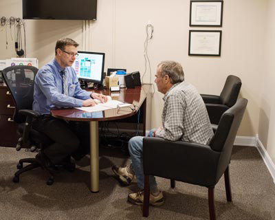 Hearing doctor examining patient at a Rumford, ME, clinic.